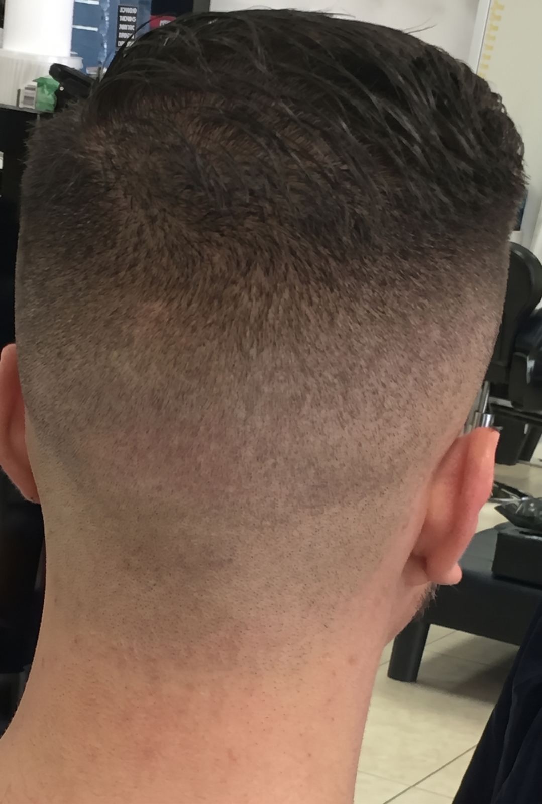 Back view of a burst taper fade, the blend running up into a short textured top.